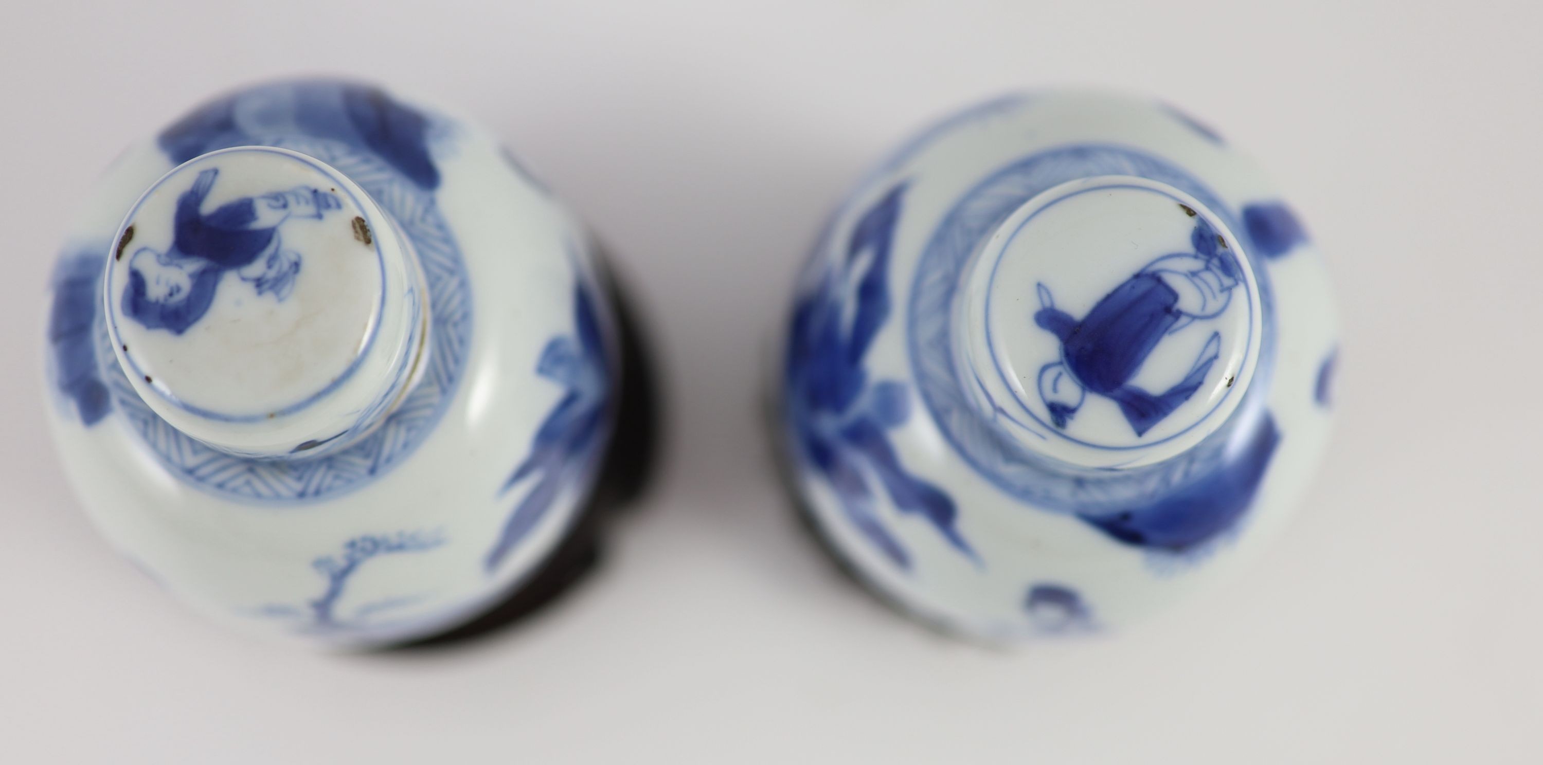 A pair of Chinese blue and white ovoid jars and covers, Kangxi period, 13.2 and 13.5 cm high, wood stands